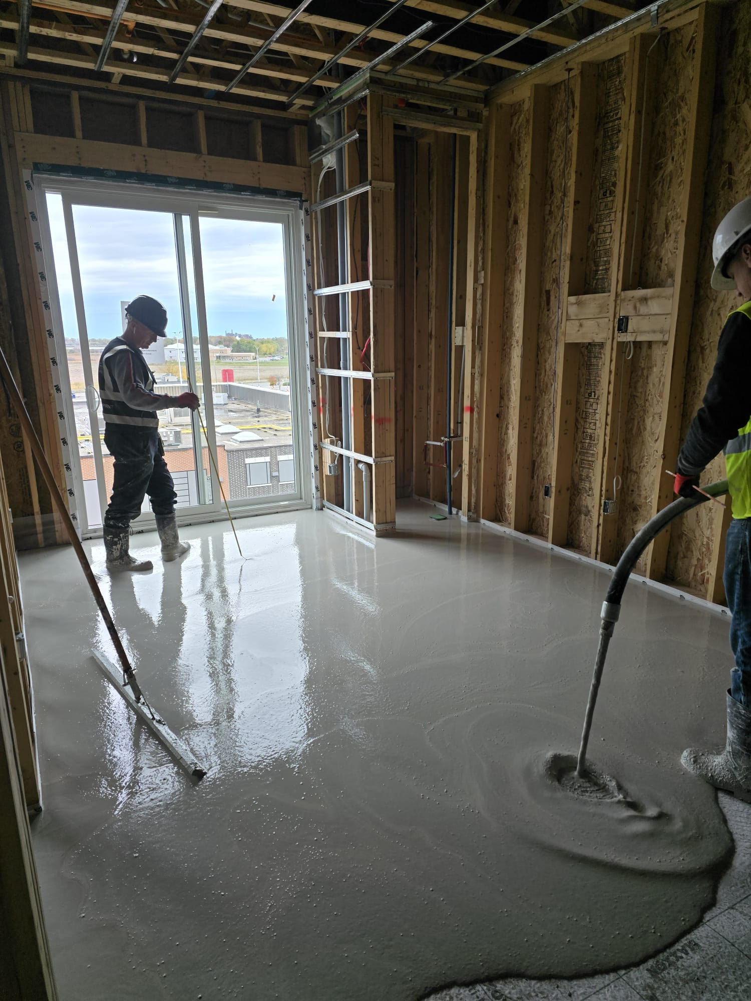 FloLayer crew pouring and smoothing self-leveling floor topping