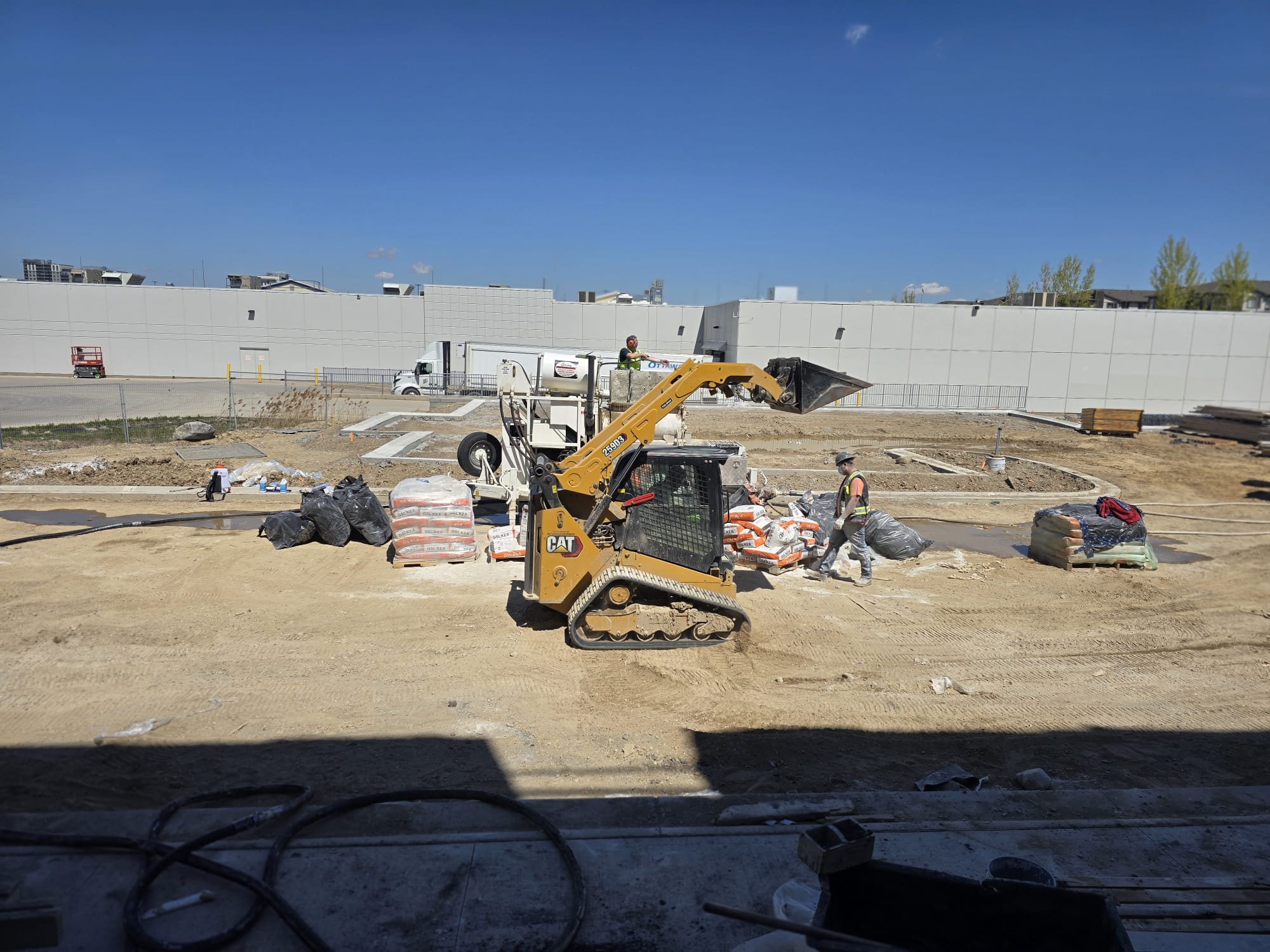 FloLayer skid steer and pump truck at a large commercial job site in Ontario